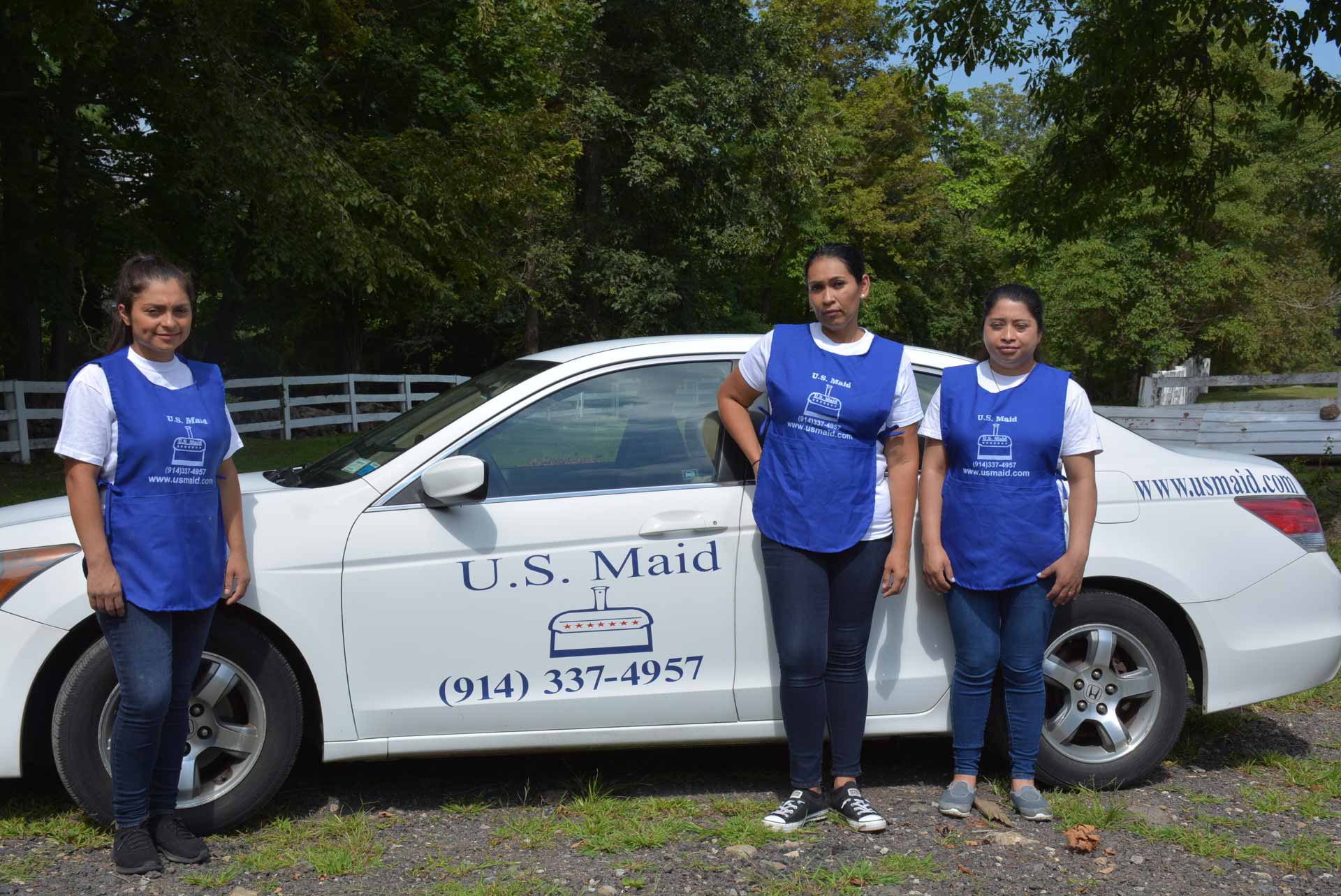 Staff from US Maid posing with a company car