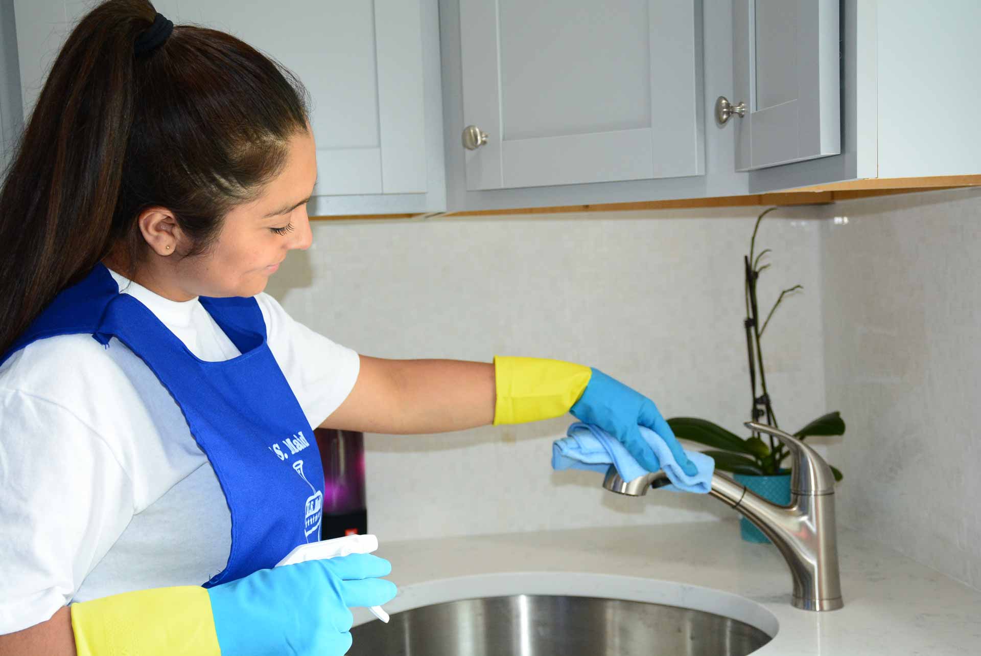 Maid wiping down faucet