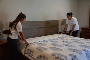 Two maids making a bed